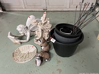Full lot view showing resin angels, raccoons, decorative plaque, planter pots and metal hangers