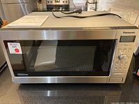 Front view of Panasonic microwave showing size, brand and overall condition on kitchen counter.