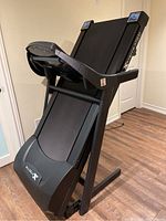 Folded treadmill in upright storage position