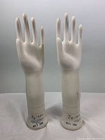 Front view of the pair of porcelain glove display molds, showing their height and shape.
