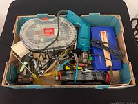 Overview of box containing the Makita drill, hand tools, and accessory cases packed together