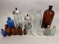 Full view of all 15 bottles in assortment showing colors, sizes, and closure types