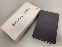 Image of white box labeled Satellite Finder and black box labeled QardioArm.