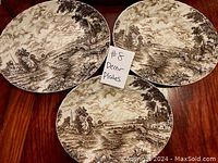 Three Ridgway Staffordshire decorative plates with brown hand engraved scenery landscapes, arranged on table