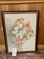 Framed painting of flowers with a note card indicating '68 Flower Paints'. The flowers are white and peach colored with stems and leaves on a neutral background. Visible signature 'Valles'.