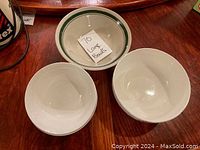 Top view of three large bowls showing plain white with green rim and plain white bowls