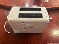 Top view of white Proctor Silex toaster showing two bread slots with metal grates and a label '#34 Toaster'.