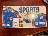 Top side of the unopened Sports Mogul board game box showing the logo and colorful game section graphics.