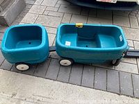 Full view of the blue Step2 children's wagon connected to smaller tag along trailer on a paved surface