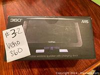Front of box showing the Veho 360 M5 portable wireless speaker with charging dock and lot number label.