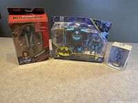 Three action figures including Batman Multiverse set, Captain America figure in packaging and a small boxed figure