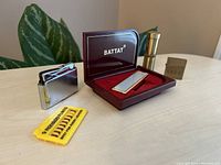 Set of four vintage lighters with Ronson flints on table with plant background