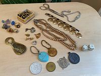 Full lot view showing jewelry, rings, scissors, keychains, and assorted accessories on a table