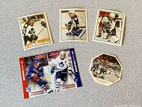 Five vintage Toronto Maple Leafs hockey cards including three square player cards, two Jell-o branded cards, all varying in size and showcasing team and players