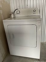 White Amana electric dryer with front load door and mechanical timer control, showing front and partial top view.