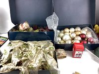 Box of assorted Christmas ball ornaments and a red box in a plastic bin