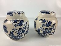 Pair of collectible Masons England miniature vases with lids, blue floral and bird motifs on white porcelain. Both round with fitted lids, about 5 inches tall.