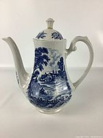 Front view of the Staffordshire ceramic teapot showing the blue pastoral design and spout.