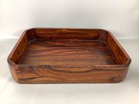 Front angled view of a rectangular wooden tray showing wood grain and depth.