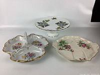 Photo showing all three fine china serving dishes with floral designs arranged together on a white background.