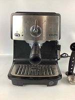 Front view of Krups espresso machine showing stainless steel control panel with knob and on/off light.