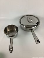 One photo showing both Lagostina stainless steel saucepan and pot with lid, indicating minor wear and polished finish.