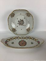 Round scalloped edge serving plate with gold trim and floral motifs on white porcelain