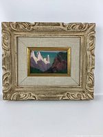 Front view of the framed miniature landscape painting showing mountain peaks and surrounding hills.
