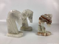 Pair of two solid stone horse head bookends on white background, showing overall look and scale.