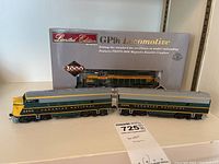 Multiple HO scale locomotives, Canadian National 6500 and 6600 in front of a boxed Limited Edition GP9 locomotive on a shelf.