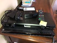 Three stacked devices: Cambridge Audio DAC on top, Panamax M4300-PM in middle, Sony BDP-S580 player on bottom, with two remotes and power adapter