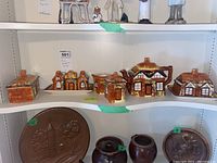 Full view of the ceramic set including cottage-shaped teapot, butter dish, cream, sugar, salt, pepper, honey pot on tray