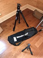 Full view of Manfrotto 486 tripod set up on floor with carrying bag alongside Cullmann tripod
