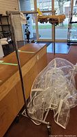 Full view of the adjustable metal clothing rack with wheels and the plastic cover wrapped at the bottom