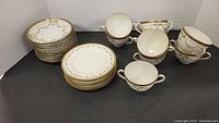 Full view of stacked saucers, side plates, and scattered teacups showing design and quantity.