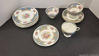 Overview of all plates and cups showing floral and ornate design with blue and gold accents