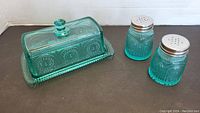 Butter dish with lid and matching salt and pepper shakers shown together.