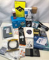 Full view of the lot showing multiple new electronics and accessories including Echo Dot Kids, cooling fans, wallet, watch, cables, mounts, and earplugs.