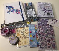 Image showing all journaling supplies together including notebook, pens, sticky notes, page markers, stickers, tape, and tape dispenser