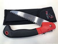 Folded and unfolded ACP folding saw displayed with carry case, showing handle and blade details.