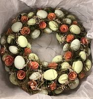Top-down view of floral egg wreath highlighting the arrangement of green eggs, orange flowers, and moss.