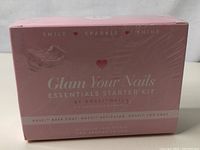 Front view of pink sealed box with 'Glam Your Nails Essentials Starter Kit' branding by Rossi.