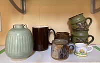 Group photo of ceramic vase and six mugs showing shapes, colors, and condition including one chipped mug.