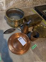 Overview of all brass and copper lot pieces on concrete floor