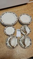 Full set image showing three dinner plates, four smaller plates, four smaller 5.5 inch plates, and three tea cups with saucers arranged together, displaying pattern and quantity.