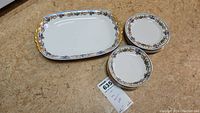 Overview photo of serving tray, plates, and saucers with tag displaying lot number