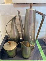 Photo showing tall coffee pot, creamer, water pitcher, and sugar bowl with wooden handles and lid knobs.