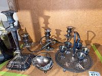 Photo showing tall candlestick, three-piece candelabra, small bowl, and aperitif glasses on a tray.