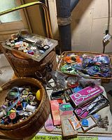 Full view of the sewing basket with multiple sewing supplies including thread spools, scissors, and wool yarn bundles.