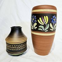 Two vintage German MCM Dumler and Breiden vases from the 1960s shown on white background, one taller and terracotta colored with floral decoration, other smaller with black and brown horizontal decorative bands